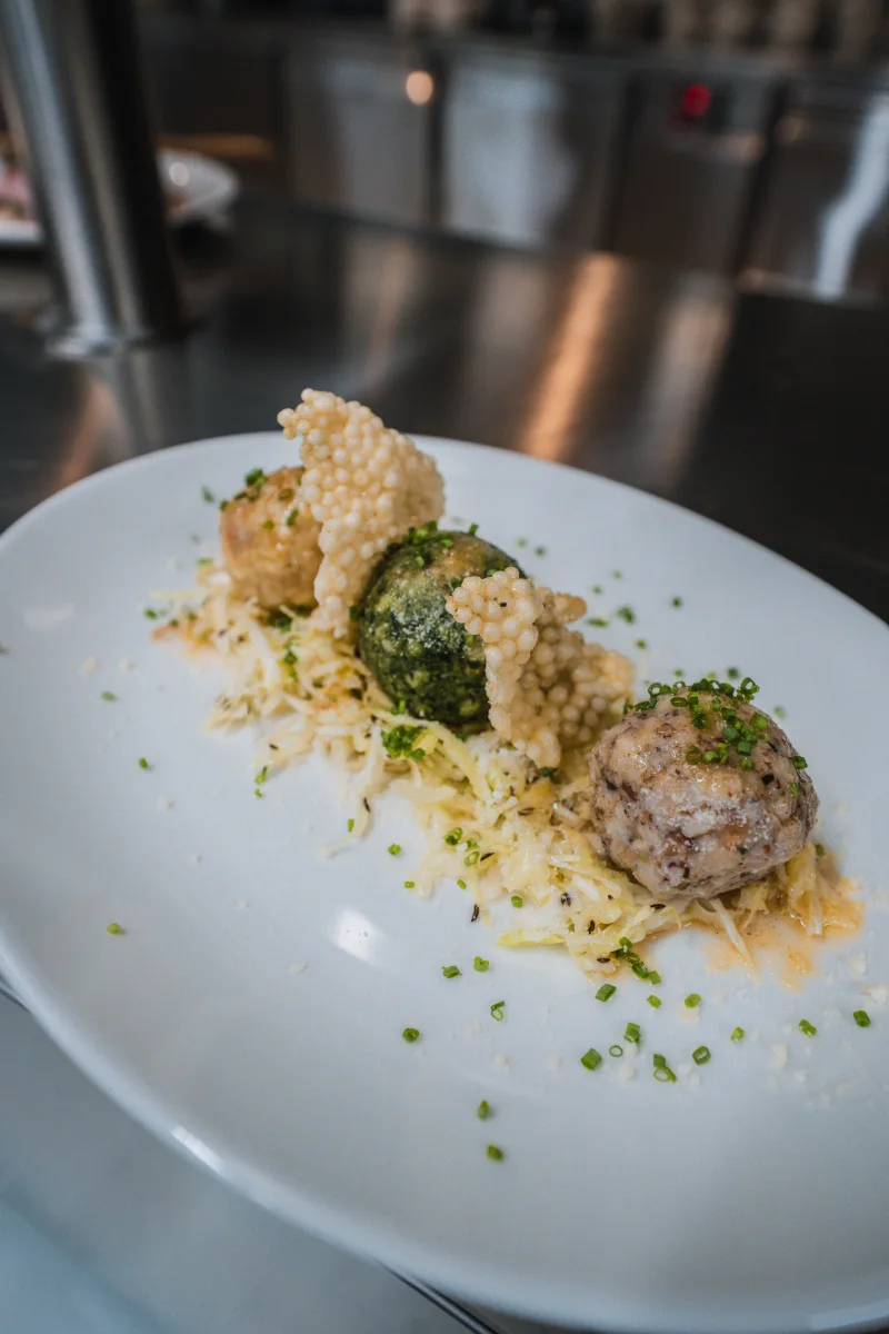 Tre canederli su verza con cialda di parmigiano