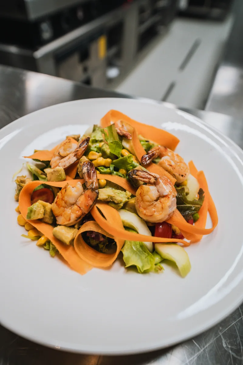 Insalata con gamberi grigliati, avocado e nastri di carota